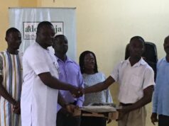 Ziko presents a laptop to Daniel Adenyor